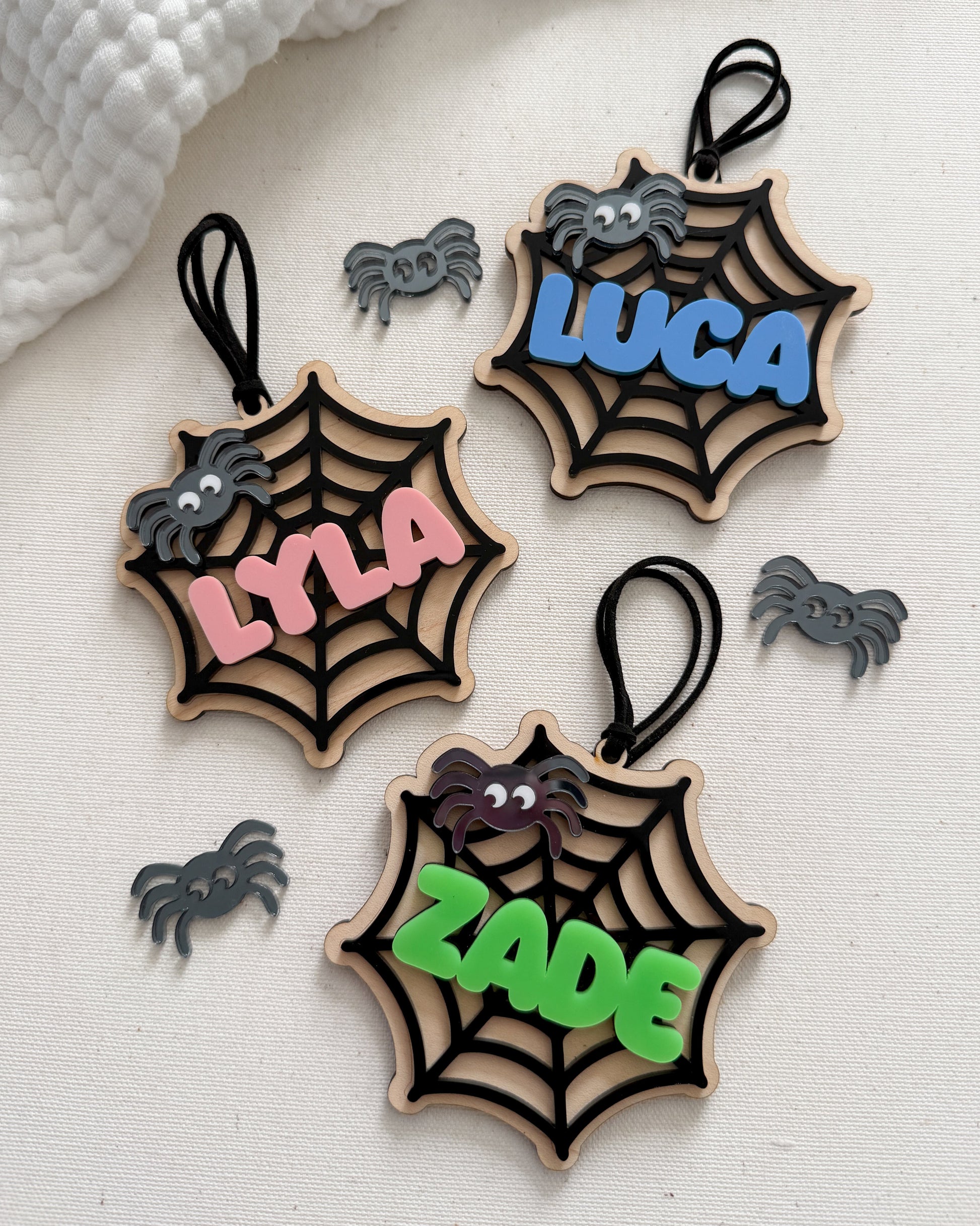 Three wooden spider web ornaments with names 'LYLA', 'LUCA', and 'ZADE' on a white background.