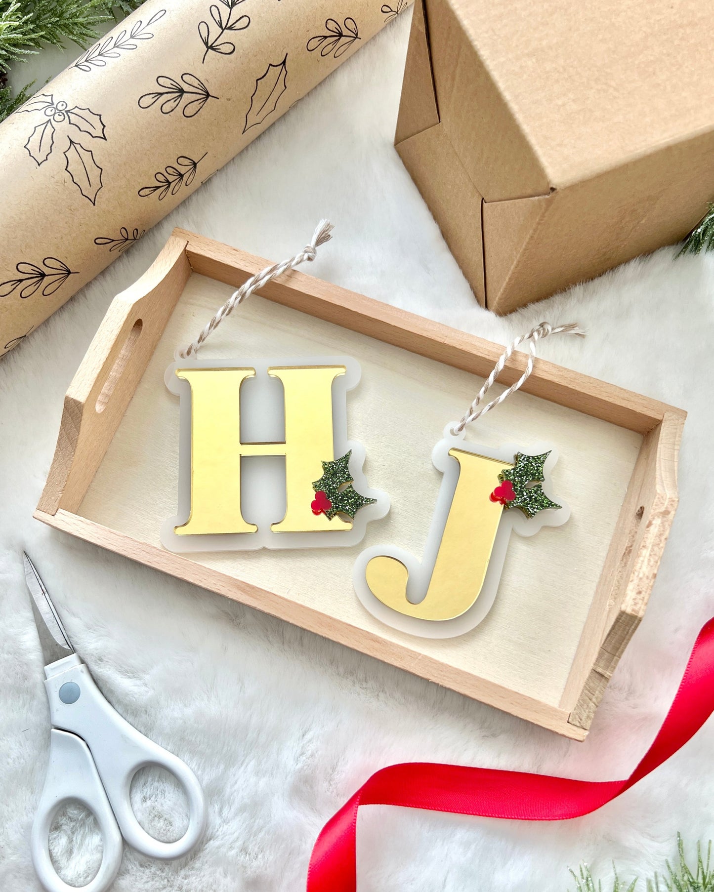 mirrored gold monogram Christmas ornament with a decorative glittery green mistletoe