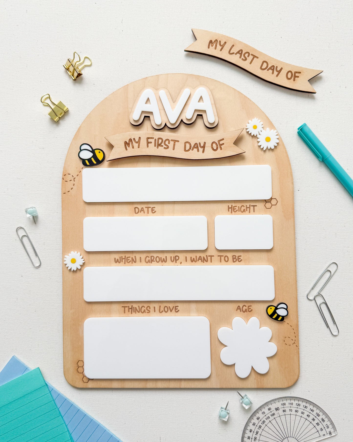 Wooden plaque with cutouts for 'My First Day of' and 'My Last Day of' with decorative elements on a light background.