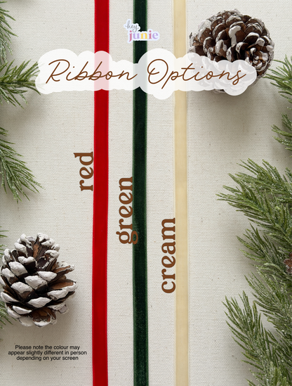 Three ribbons in red, green, and cream with pine cones and greenery on a white background.
