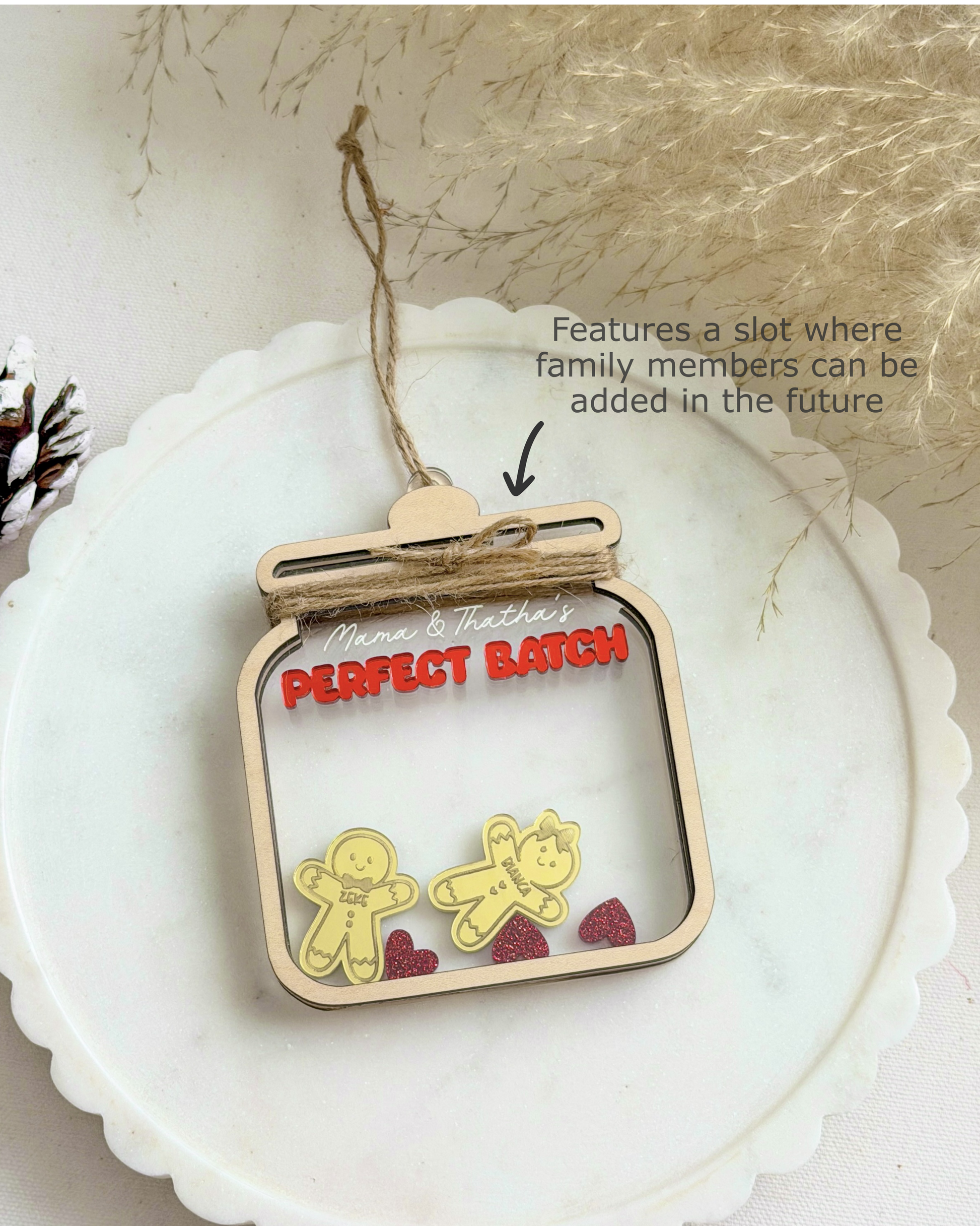 Decorative ornament with 'Perfect Batch' text and gingerbread men figures on a white surface.