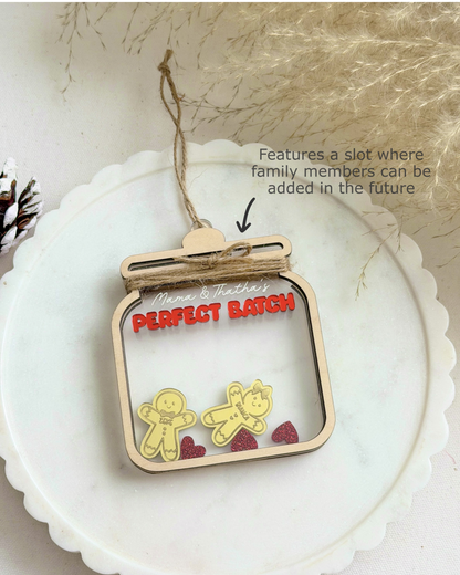 Decorative ornament with 'Perfect Batch' text and gingerbread men figures on a white surface.