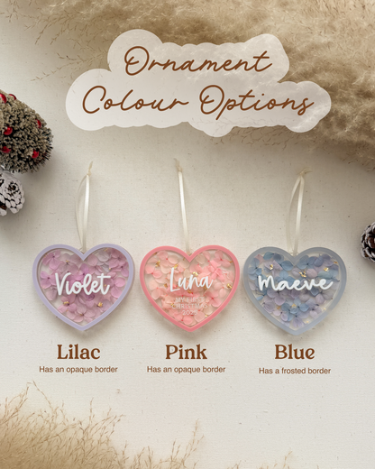 Heart-shaped ornaments with color options 'Violet', 'Luna', and 'Maeve' on a textured beige background.
