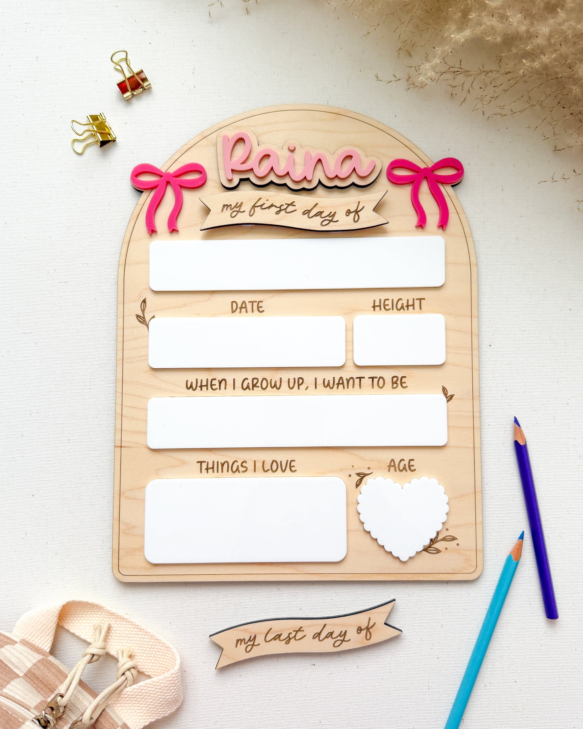Wooden plaque with cut-out letters spelling 'Raina' and placeholders for personal information on a light background.
