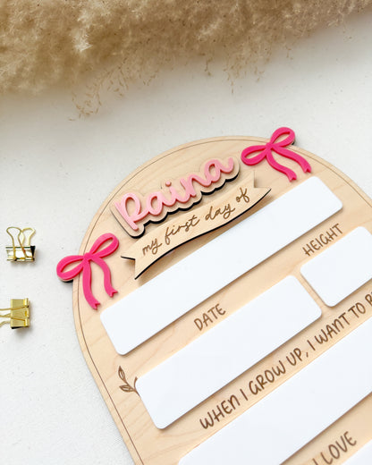 Wooden plaque with 'Raine' and decorative elements on a white background