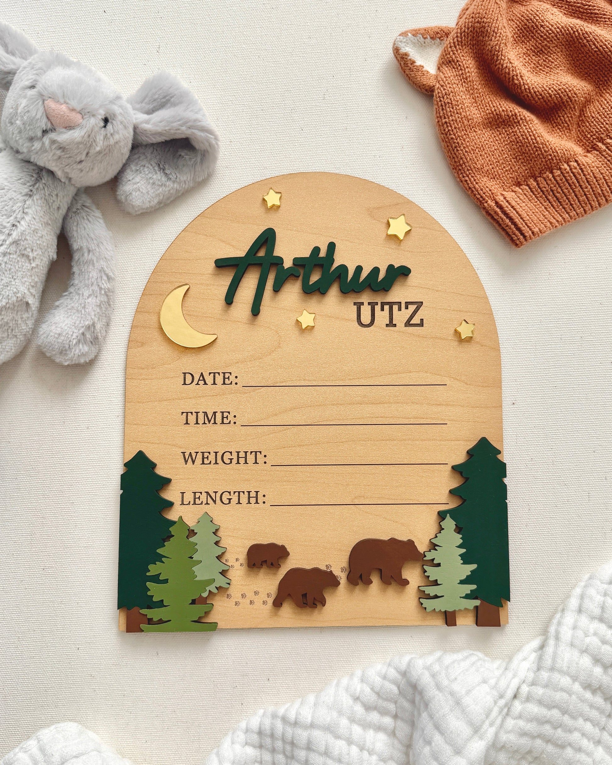 Wooden baby milestone board with decorative elements on a light background