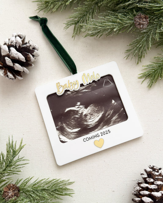 Decorative ornament with ultrasound photo and pine cones on a light background