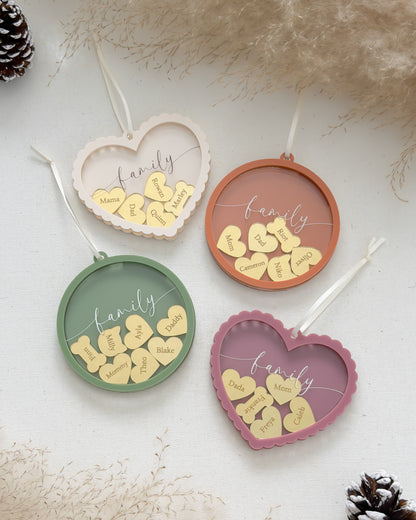 Four heart-shaped decorative items with 'family' and leaf designs on a textured surface.