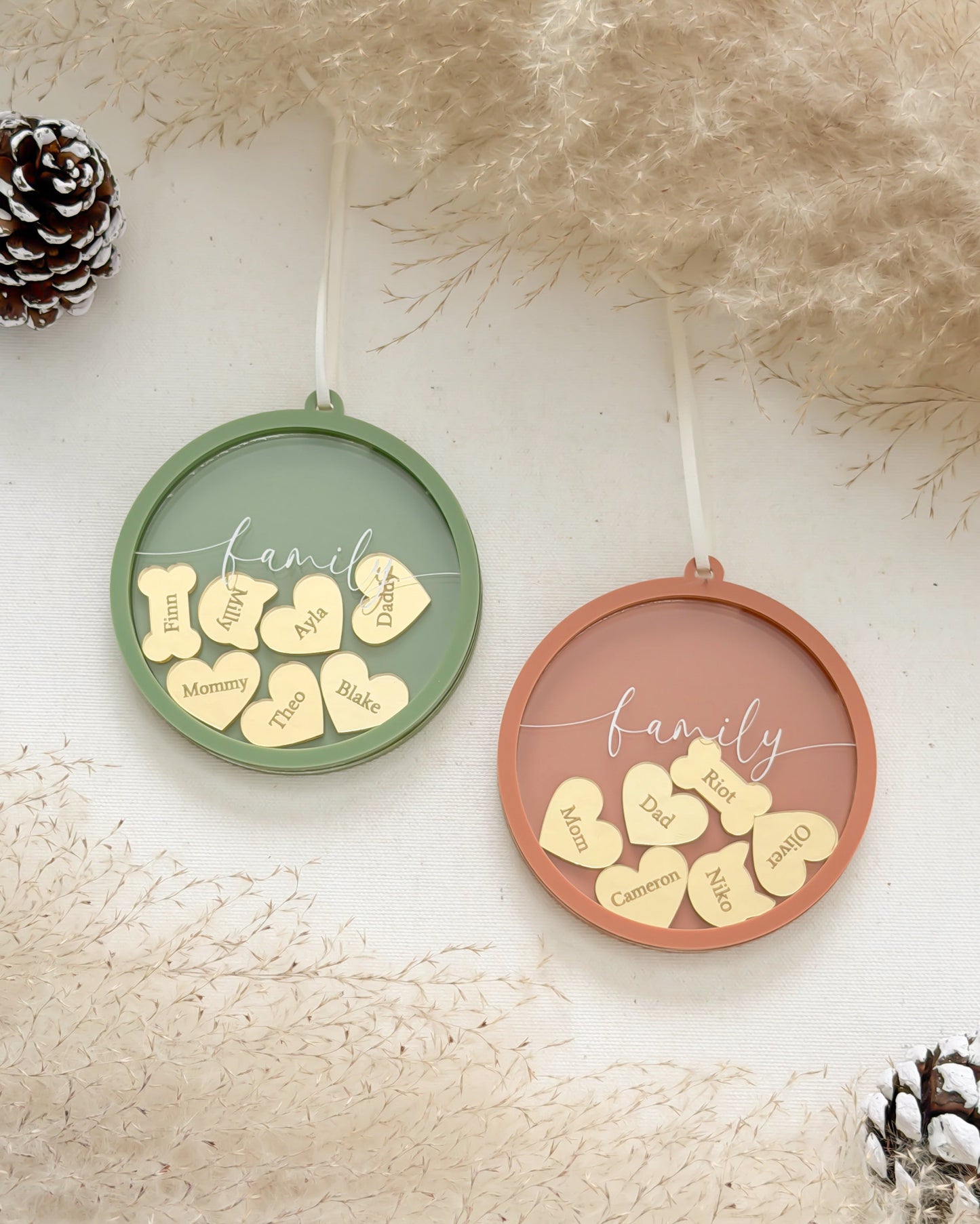 Two circular ornaments with decorative text on a textured surface with pine cones.