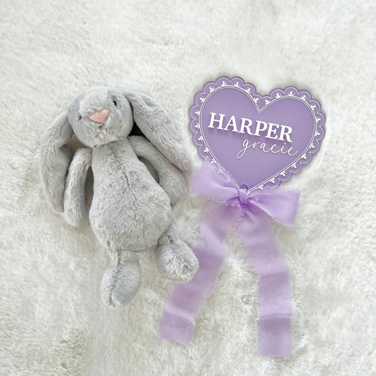 a personalized acrylic baby announcement name sign that has a lace pattern laser engraved and a chiffon bow