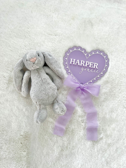 a personalized acrylic baby announcement name sign that has a lace pattern laser engraved and a chiffon bow