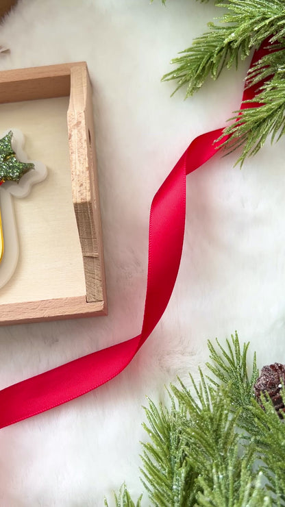 gold monogram Christmas ornament with a decorative glittery green mistletoe .